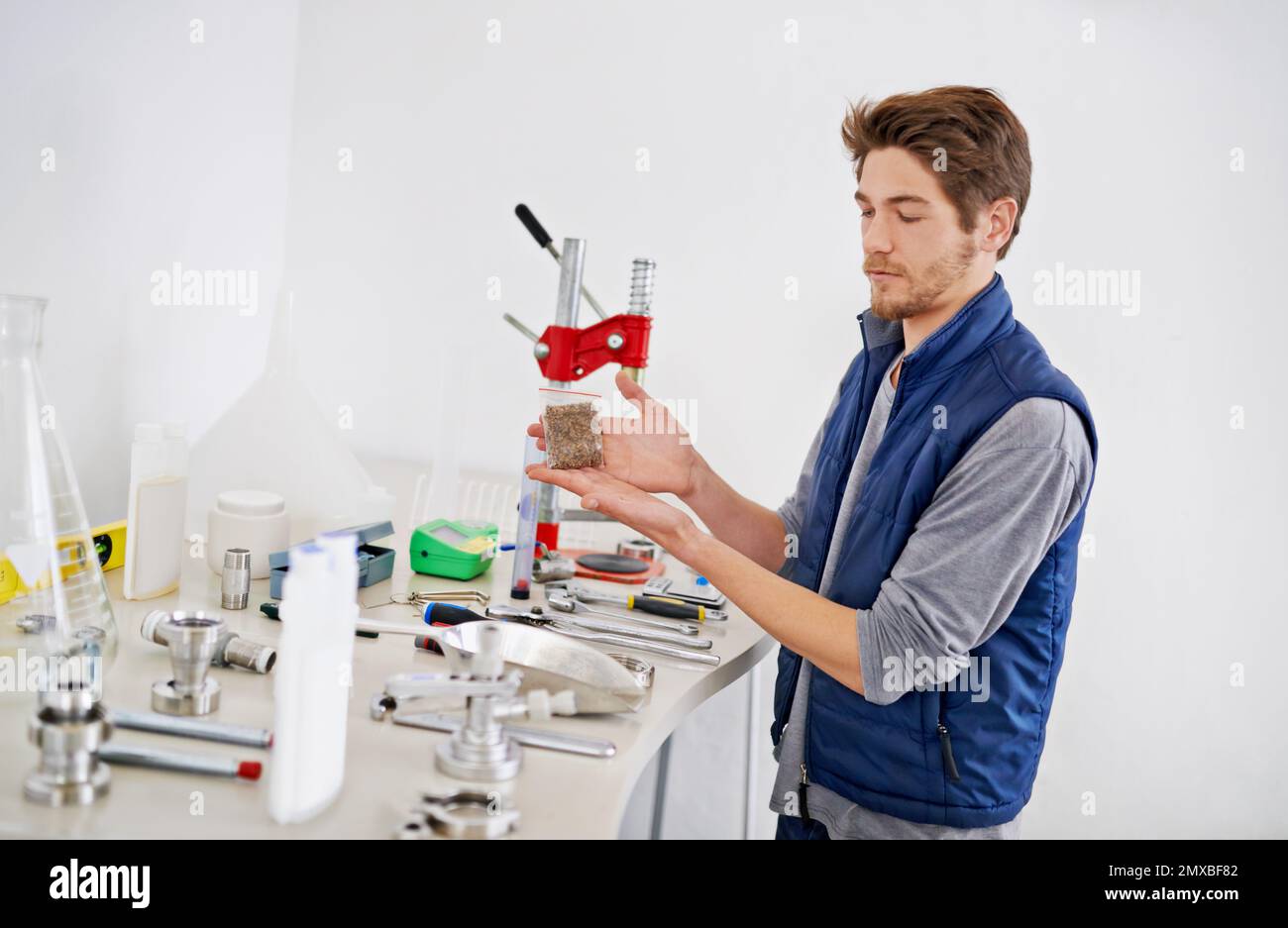 HES un esperto di birra artigianale. un giovane uomo che lavora con il luppolo da birra. Foto Stock