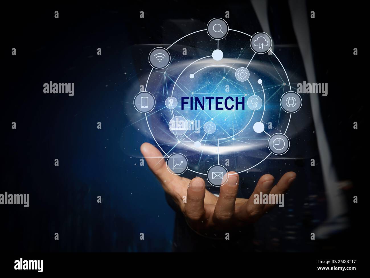Concetto FinTech. Uomo che mostra diverse icone su sfondo blu scuro, primo piano Foto Stock