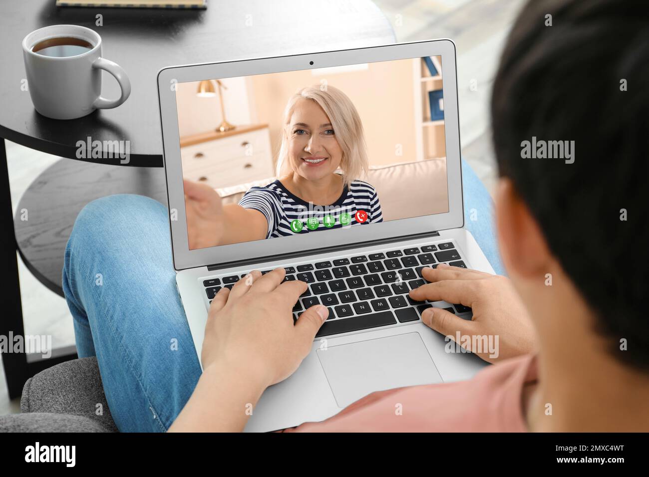 Giovane uomo che ha una videochat con sua nonna a casa, concentrati sullo schermo Foto Stock