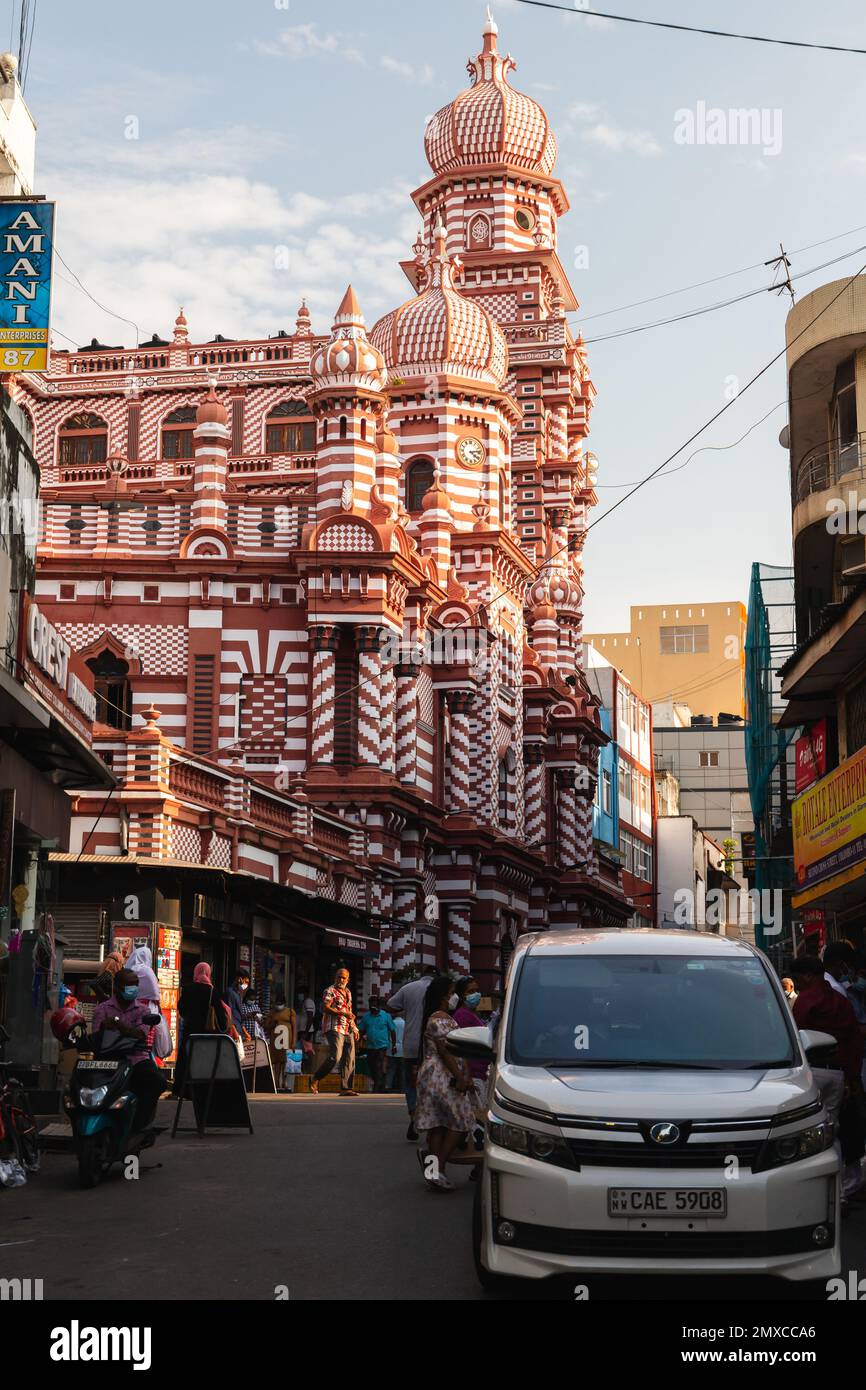 Colombo, Sri Lanka - 3 dicembre 2021: Foto di strada verticale con la Moschea Jami UL-Alfar, nota come la Moschea Rossa. Le persone e le auto comuni sono in t Foto Stock