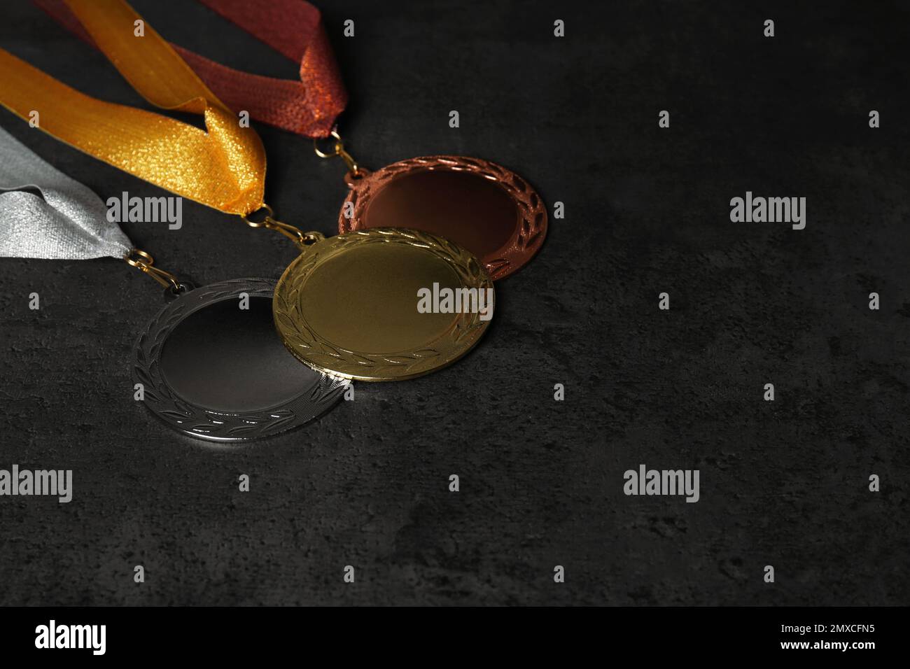 Medaglie d'oro, d'argento e di bronzo su fondo in pietra grigia. Spazio per il design Foto Stock