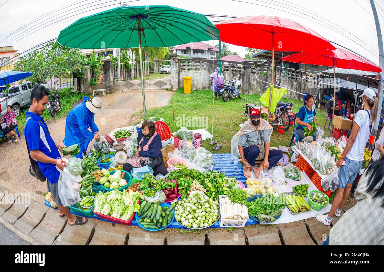 24 gennaio 2023 - Chumphon Thailandia-mercato affollato che vende verdure. Venditori con una maschera dietro la stalla. Foto Stock