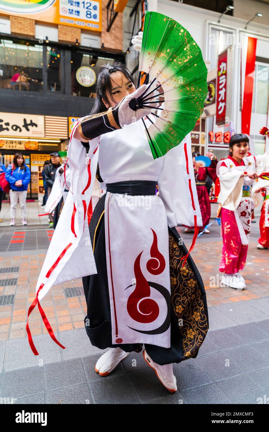 Primo piano, giovane donna giapponese Yosakoi ballerina in costume bianco e nero, con un fan verde, al festival Kyusyu Gassai di Kumamoto. Foto Stock