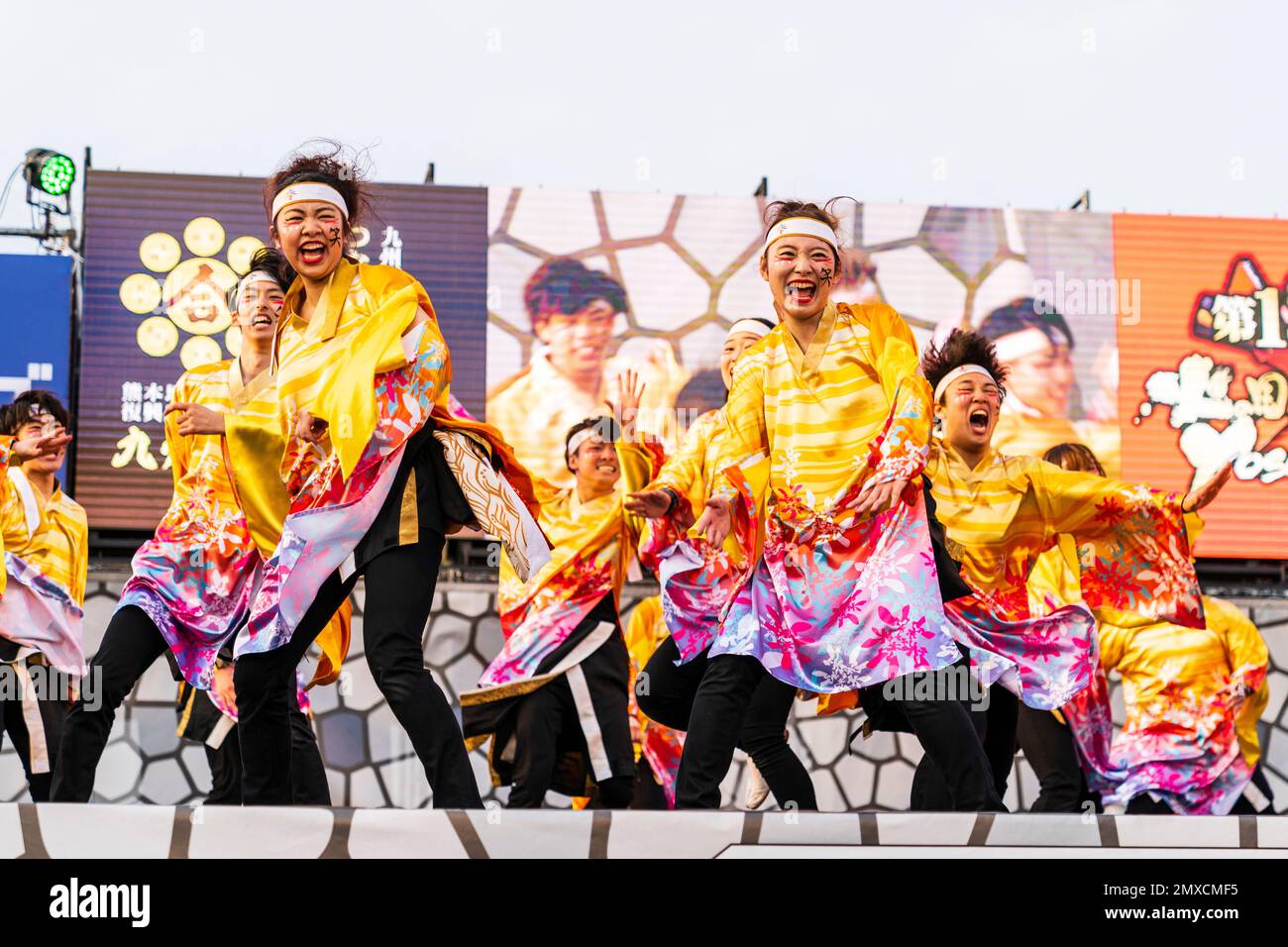 Squadra giapponese di giovani ballerini Yosakoi che ballano in yukata tunica a maniche lunghe su un palco all'aperto al festival annuale Kyusyu Gassai a Kumamoto. Foto Stock