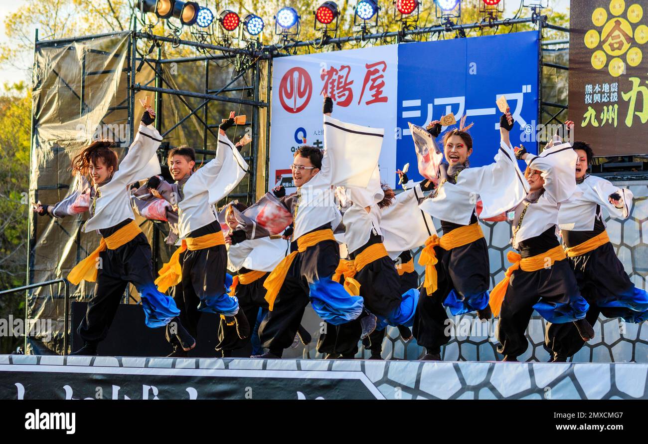 Squadra giapponese di ballerini Yosakoi con naruko, che ballano in toniche a maniche lunghe yukata sul palco all'aperto all'annuale festival Kyusyu Gassai di Kumamoto. Foto Stock