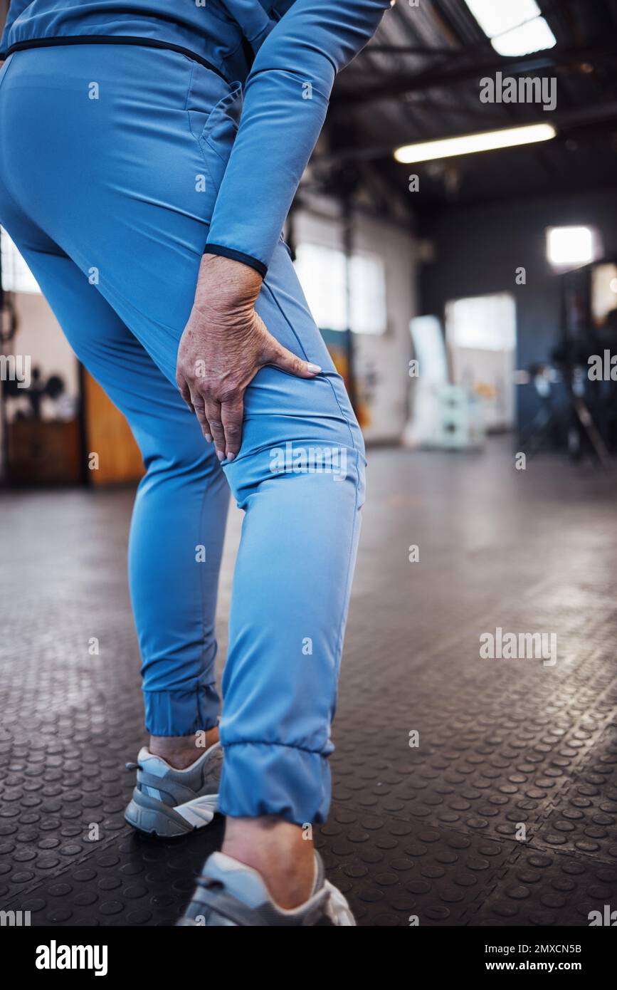 Lesioni alle gambe, incidenti e dolore in palestra dopo allenamento, allenamento o esercizio sportivo con lividi. Fitness, sport e atleta donna che zoppa da un gonfio Foto Stock