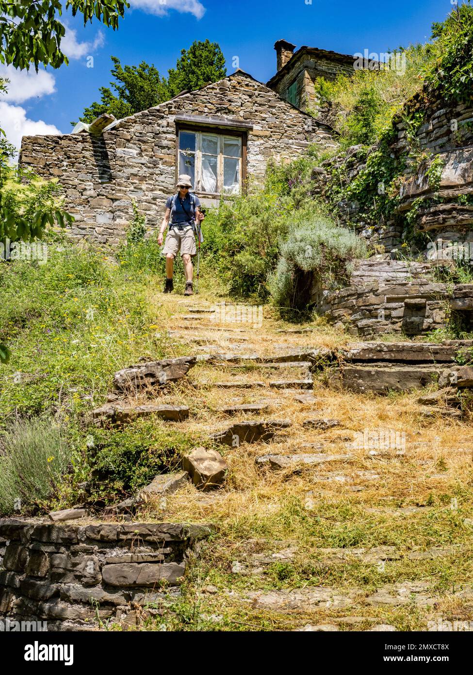 Camminatore scendendo ripide tracce attraverso il villaggio di montagna di Kipi nella regione Zagori di Epiro Grecia settentrionale Foto Stock