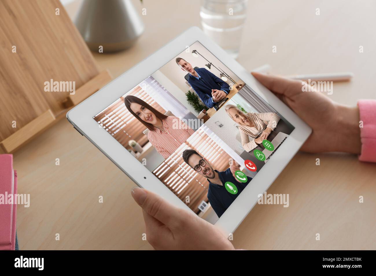 Donna che ha video chat con i colleghi al tavolo in ufficio, primo piano. Lavoro di squadra Foto Stock