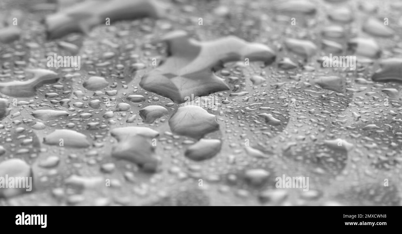 Macro full frame che mostra gocce d'acqua su una superficie metallica spazzolata Foto Stock