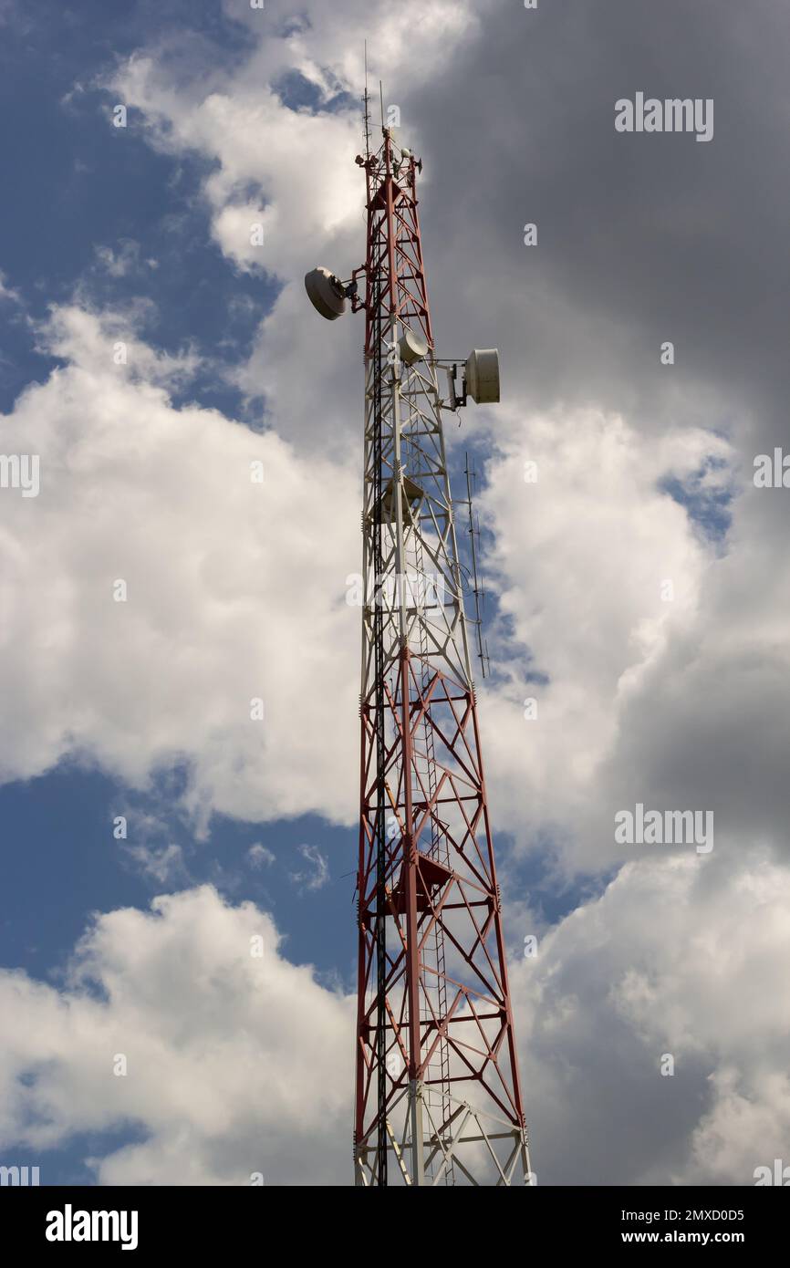 Torre di telecomunicazione per telefono cellulare con antenne su un cielo blu. Funzione di distribuzione dei telefoni cellulari a contratto. Foto Stock