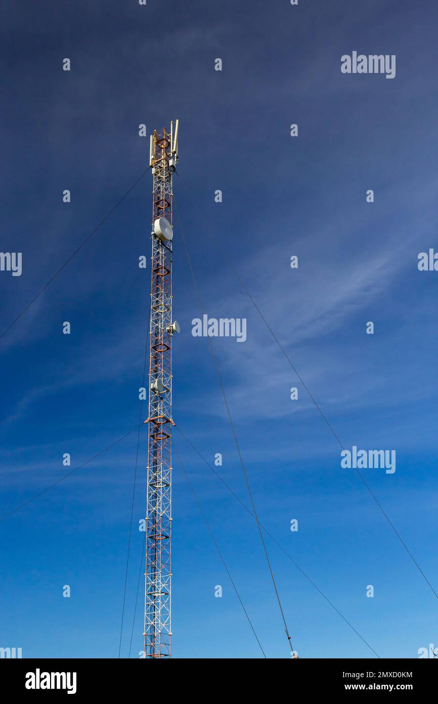 Torre delle telecomunicazioni con sistema di antenna radio, microonde e  televisione situata nella foresta contro il cielo blu. Torre dell'antenna,  vista dal Foto stock - Alamy