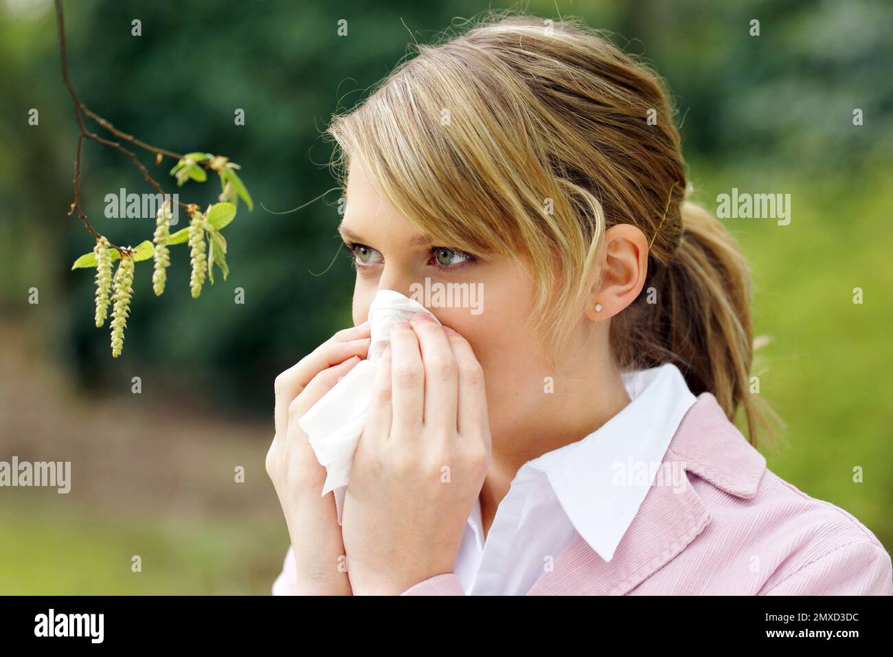 Carpino comune, carpino europeo (Carpinus betulus), giovane donna con allergia al polline Foto Stock