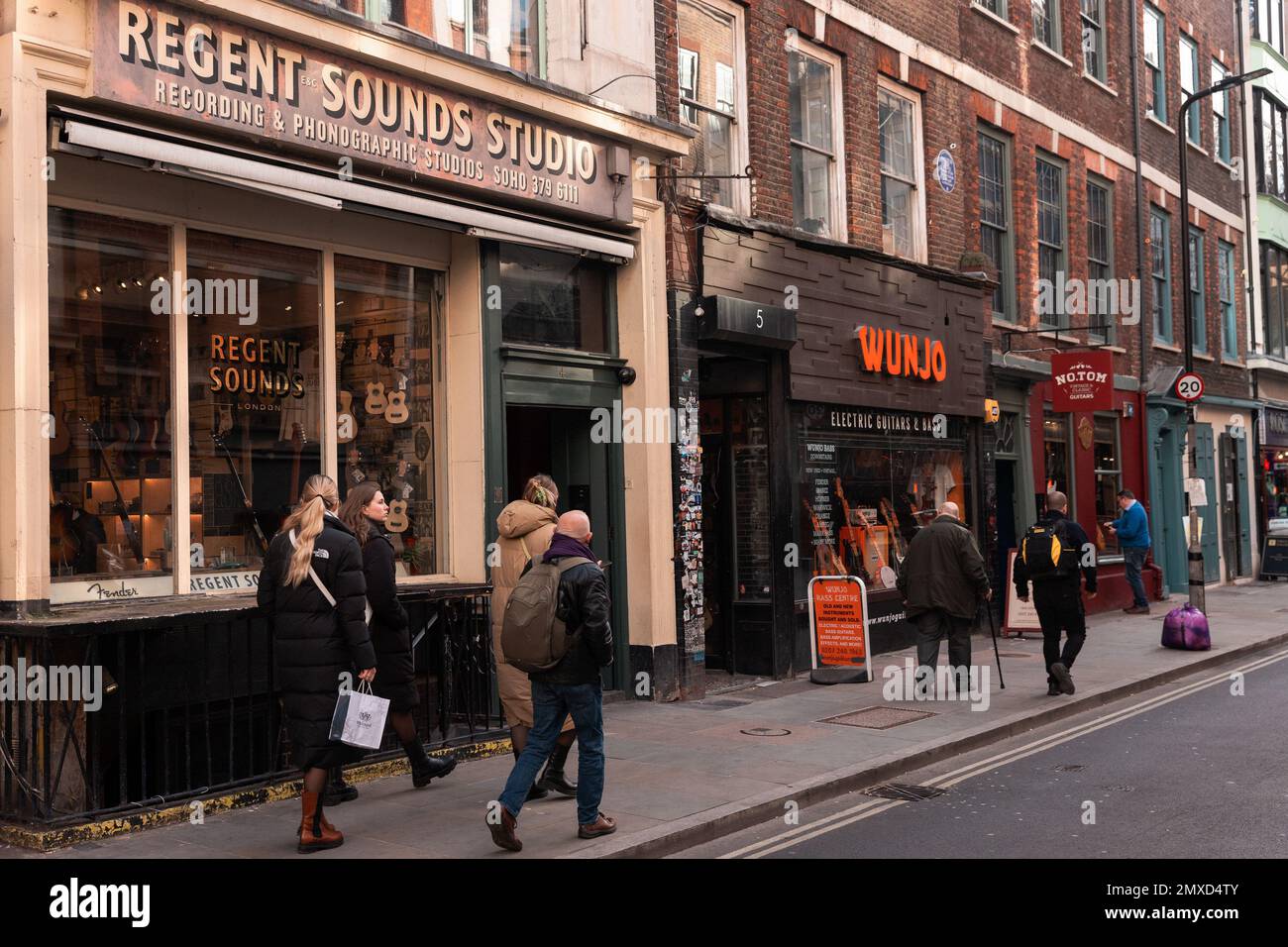 Londra, Regno Unito. 30th gennaio 2023. Membri del pass pubblico Regent Sounds Studio in Denmark Street. Lo studio, che è ora un negozio di chitarra, operò tra il 1951 e i primi anni '1980s, ospitando i Rolling Stones, l'esperienza di Jimi Hendrix, i Kinks, l'OMS, il Sabbath Nero, i Bees Bee, Tom Jones e gli Yardbirds tra gli altri. Denmark Street sta attualmente vivendo una notevole ristrutturazione a causa di Crossrail. Credit: Notizie dal vivo di Mark Kerrison/Alamy Foto Stock