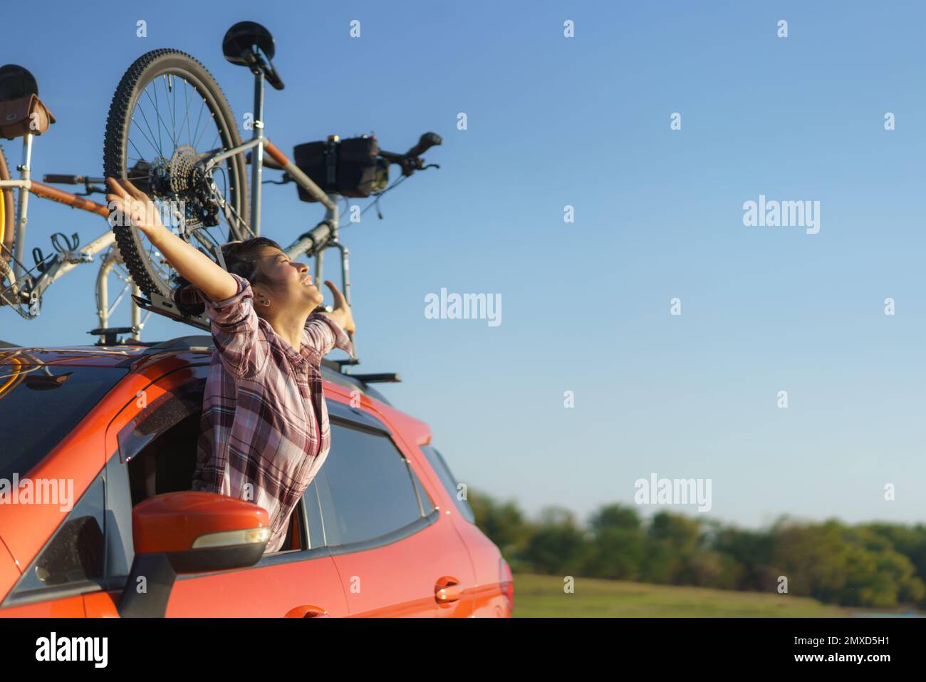 Donna asiatica esce dalla finestra dell'auto per respirare aria fresca durante il viaggio in campeggio Foto Stock