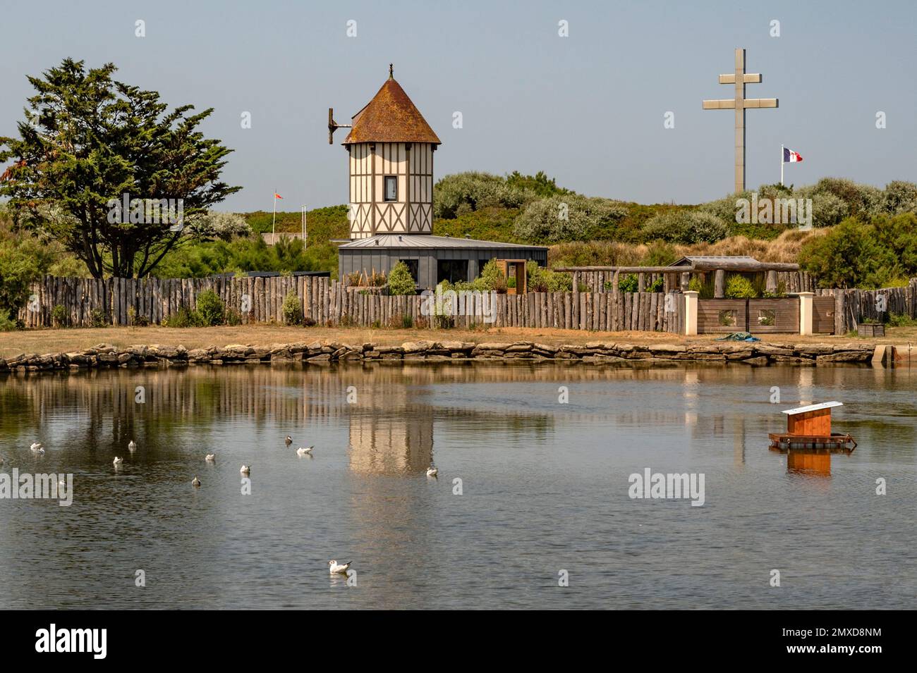 Lago tranquillo e croce di guerra (croix de lorraine) a Courseulles-sur-Mer sulle spiagge dello sbarco in Normandia, Francia Foto Stock