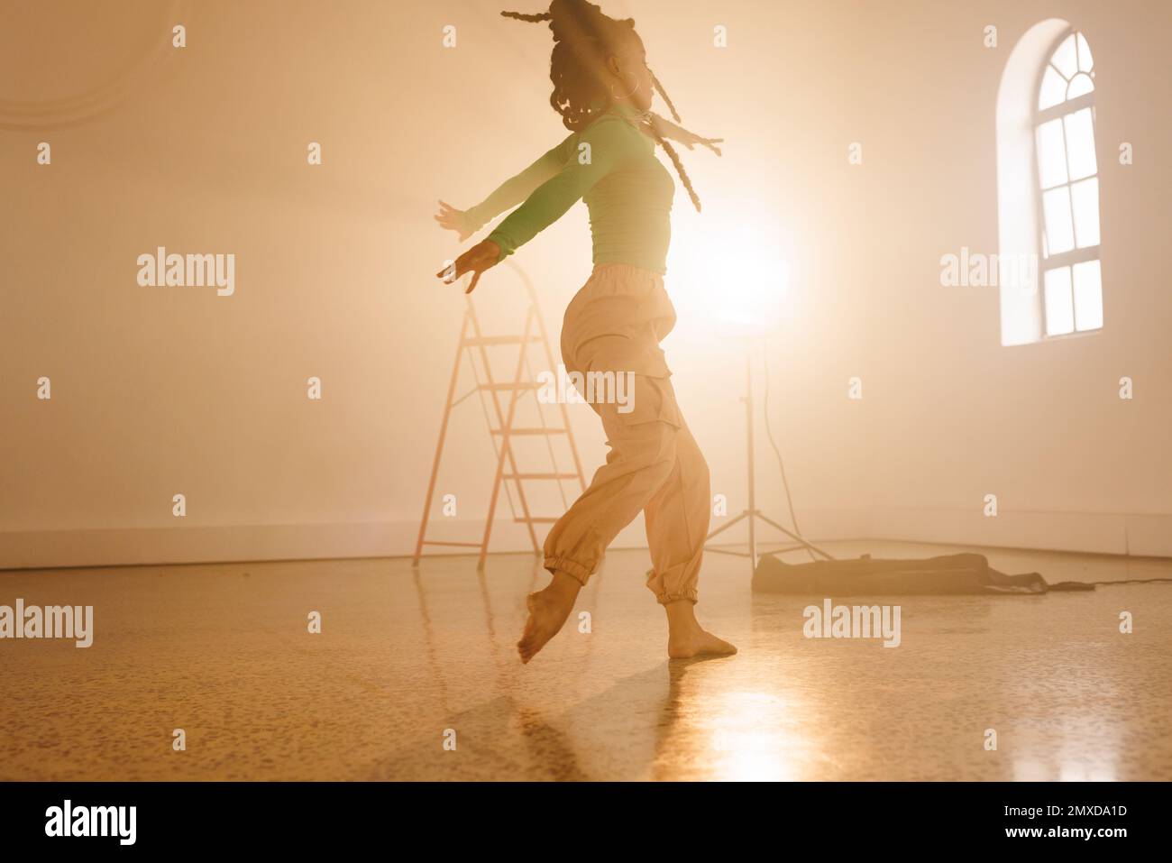 Immagine di danza moderna femminile biraciale in interni affumicati. Danza, arte del ritmo e concetto di movimento. Foto Stock