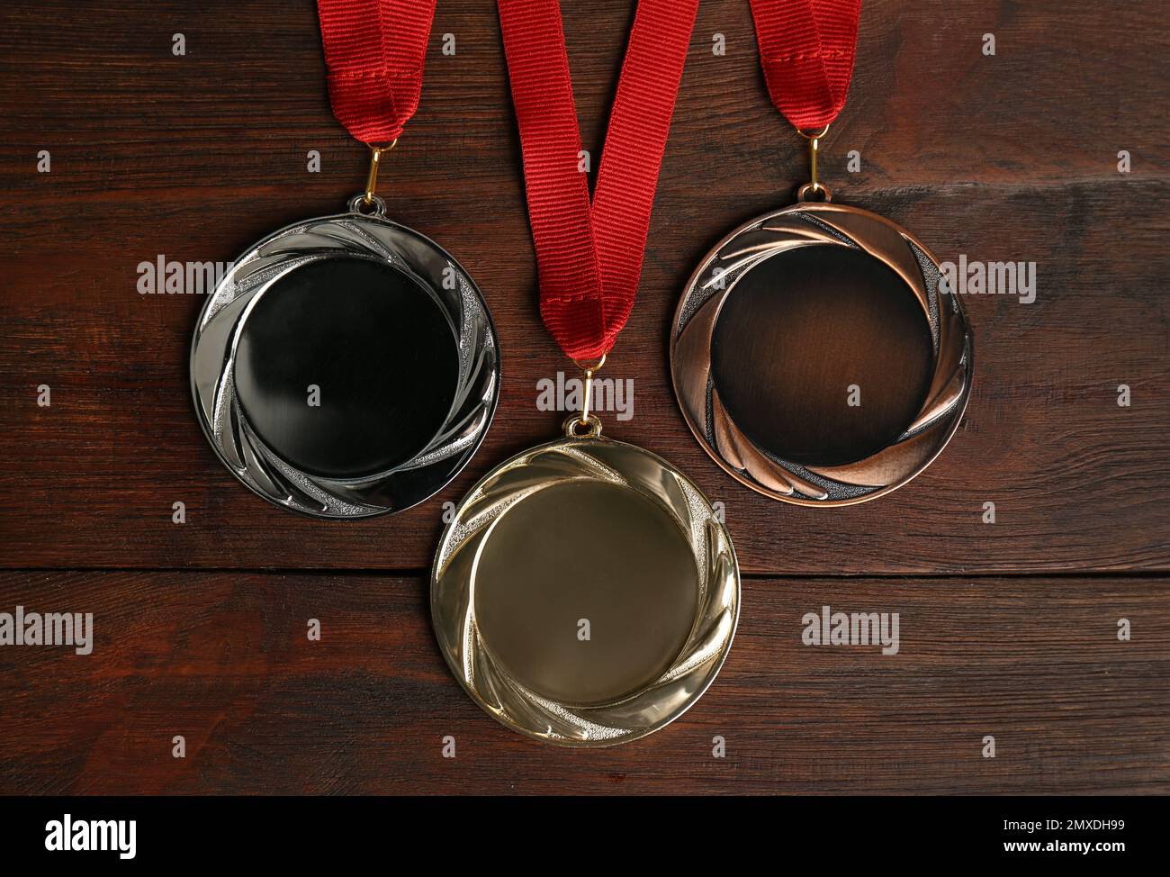 Medaglie d'oro, d'argento e di bronzo su sfondo ligneo, giacitura piatta. Spazio per il design Foto Stock