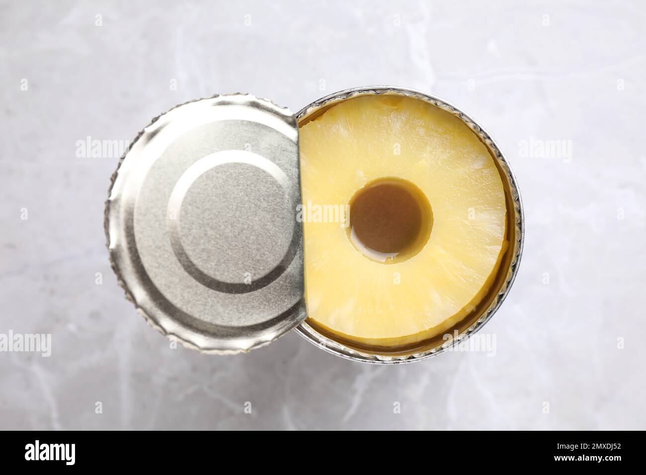 Teglia aperta con ananas in scatola su tavolo in marmo grigio chiaro, vista dall'alto Foto Stock