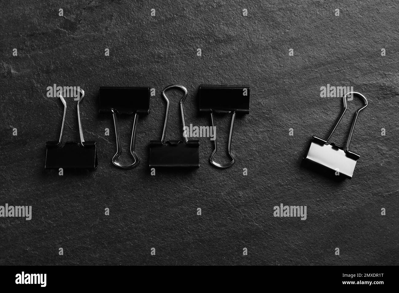 Composizione piatta con clip di carta su sfondo nero ardesia. Principio di Pareto Foto Stock