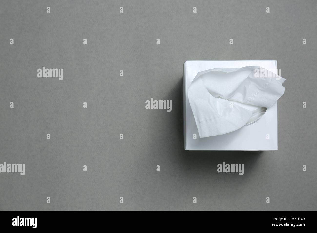 Confezione di fazzolettini di carta su sfondo grigio, vista dall'alto. Spazio per il testo Foto Stock