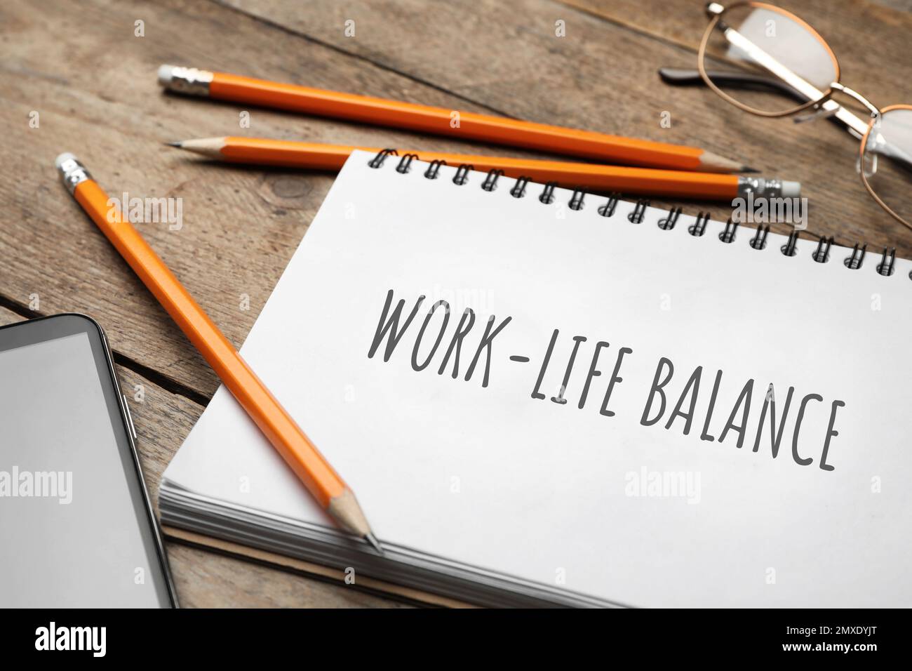 Concetto di equilibrio tra vita lavorativa e vita privata. Notebook, smartphone e matite su tavolo di legno, guardaroba Foto Stock