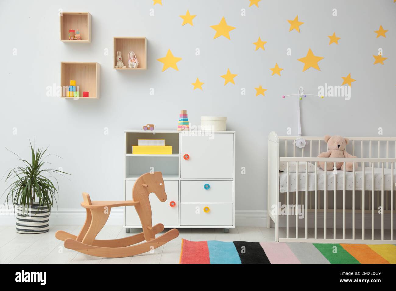 Interno della camera per bambini con una comoda culla e una sedia a dondolo  Foto stock - Alamy