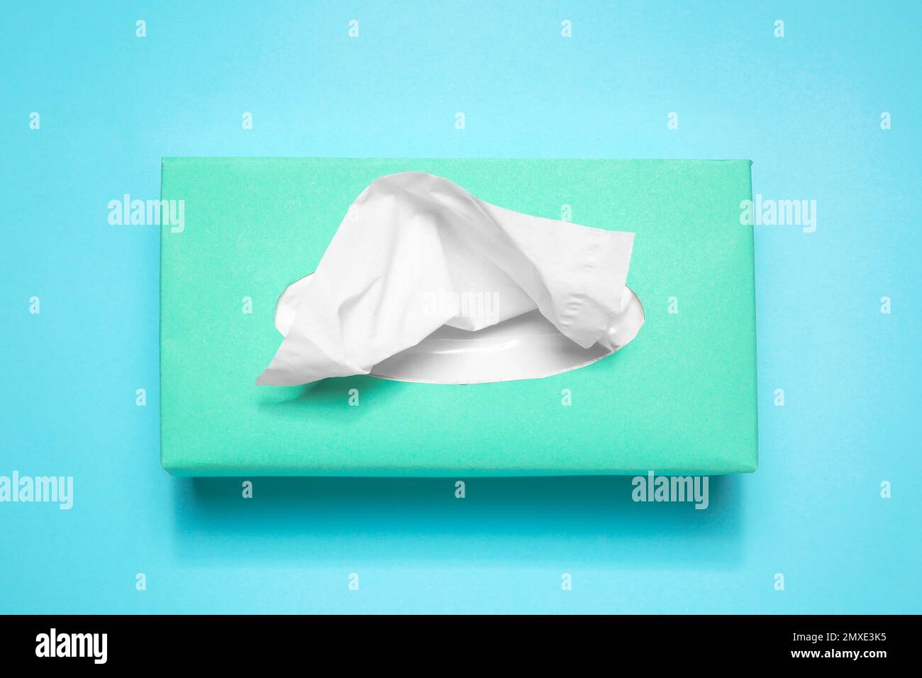 Scatola con fazzolettini di carta su sfondo azzurro, vista dall'alto Foto Stock