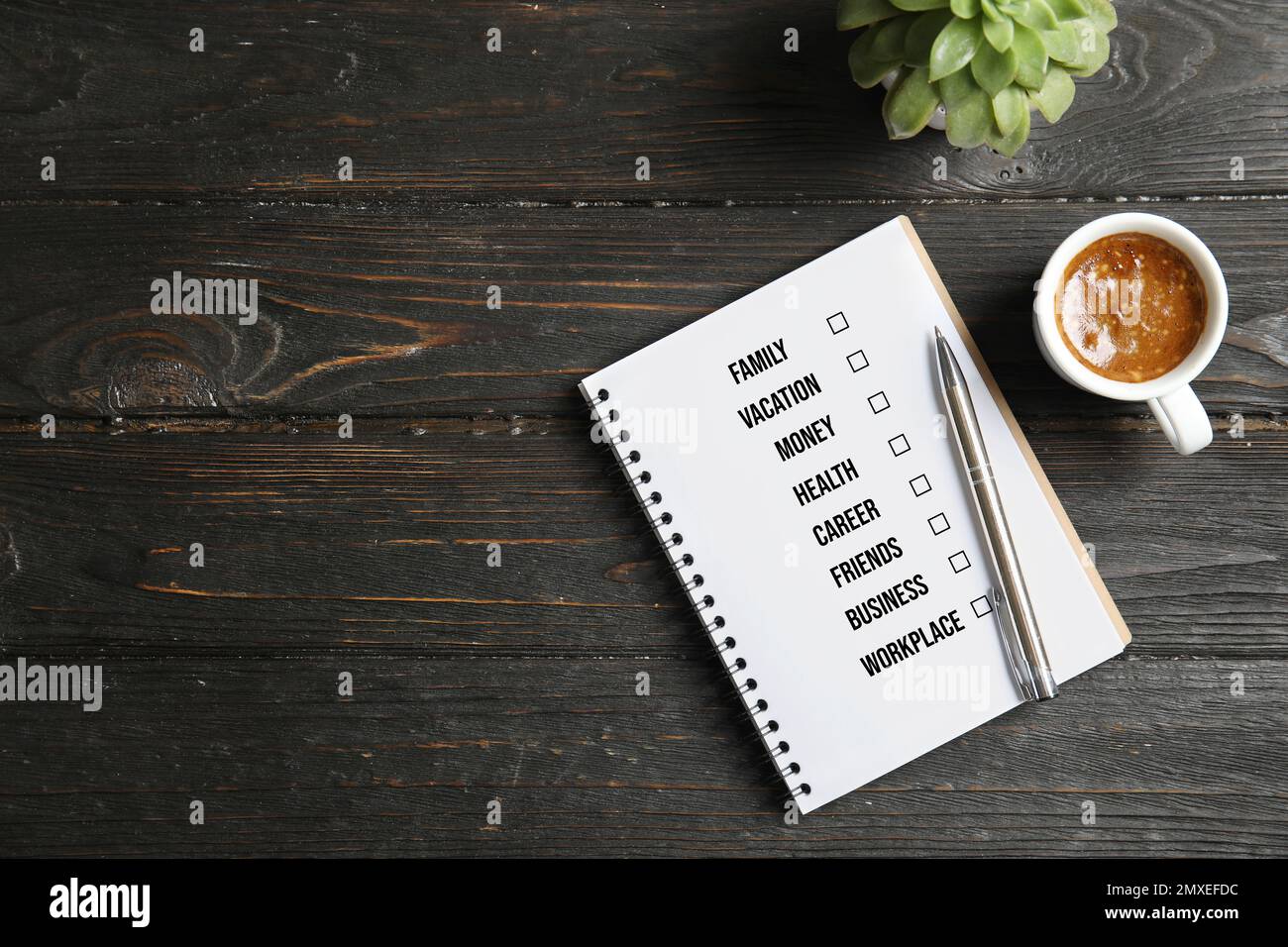 Concetto di equilibrio tra vita lavorativa e vita privata. Composizione piatta con notebook, caffè e spazio per il testo su sfondo di legno scuro Foto Stock