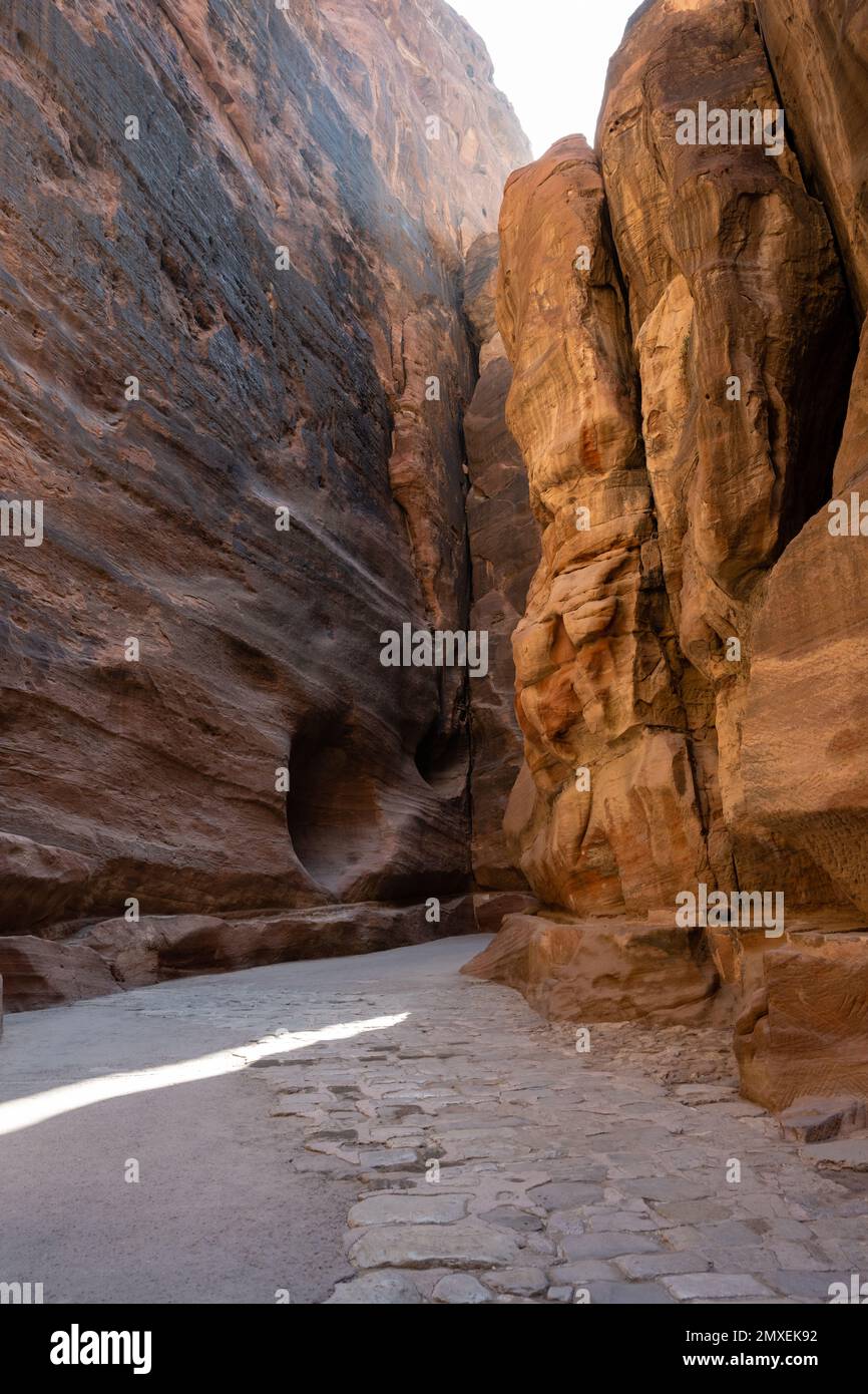 Al Siq Gorge a Petra, Giordania con antica Cobblestone Nabataean o pietra lastricata strada Foto Stock