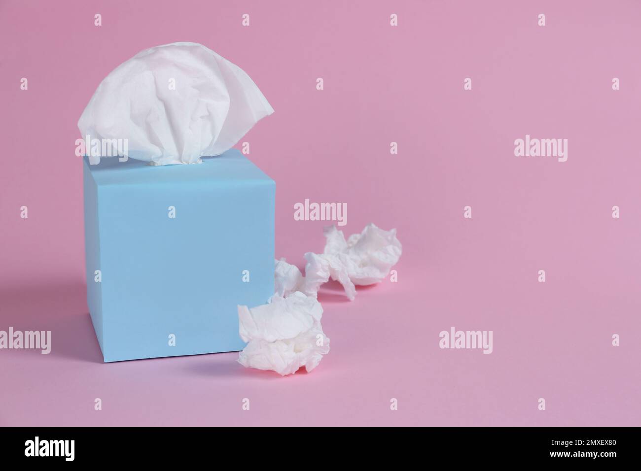 Scatola con fazzolettini di carta e tovaglioli stropicciati usati su sfondo  rosa, spazio per il testo Foto stock - Alamy