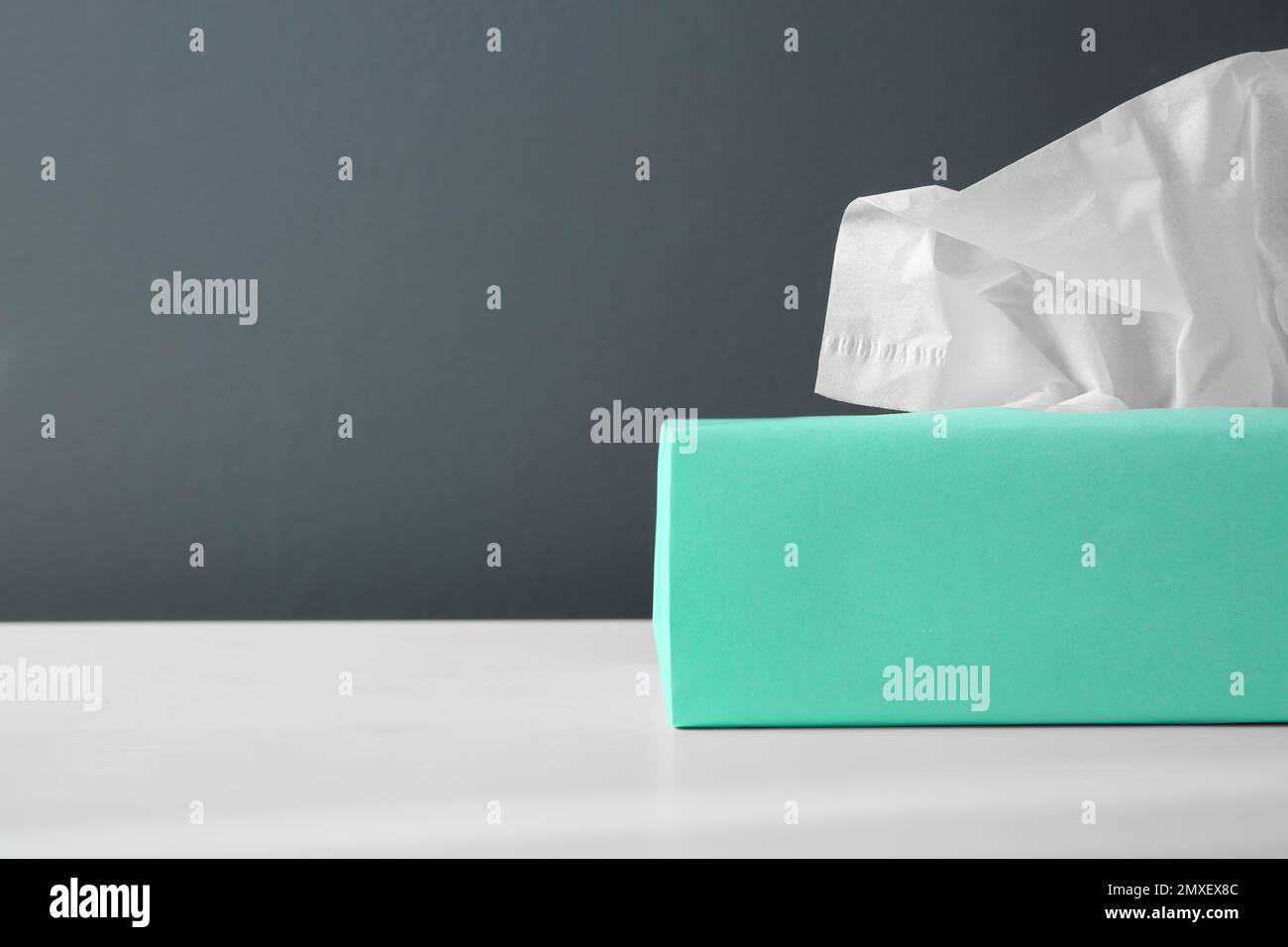 Scatola con fazzolettini di carta su tavolo bianco. Spazio per il testo Foto Stock