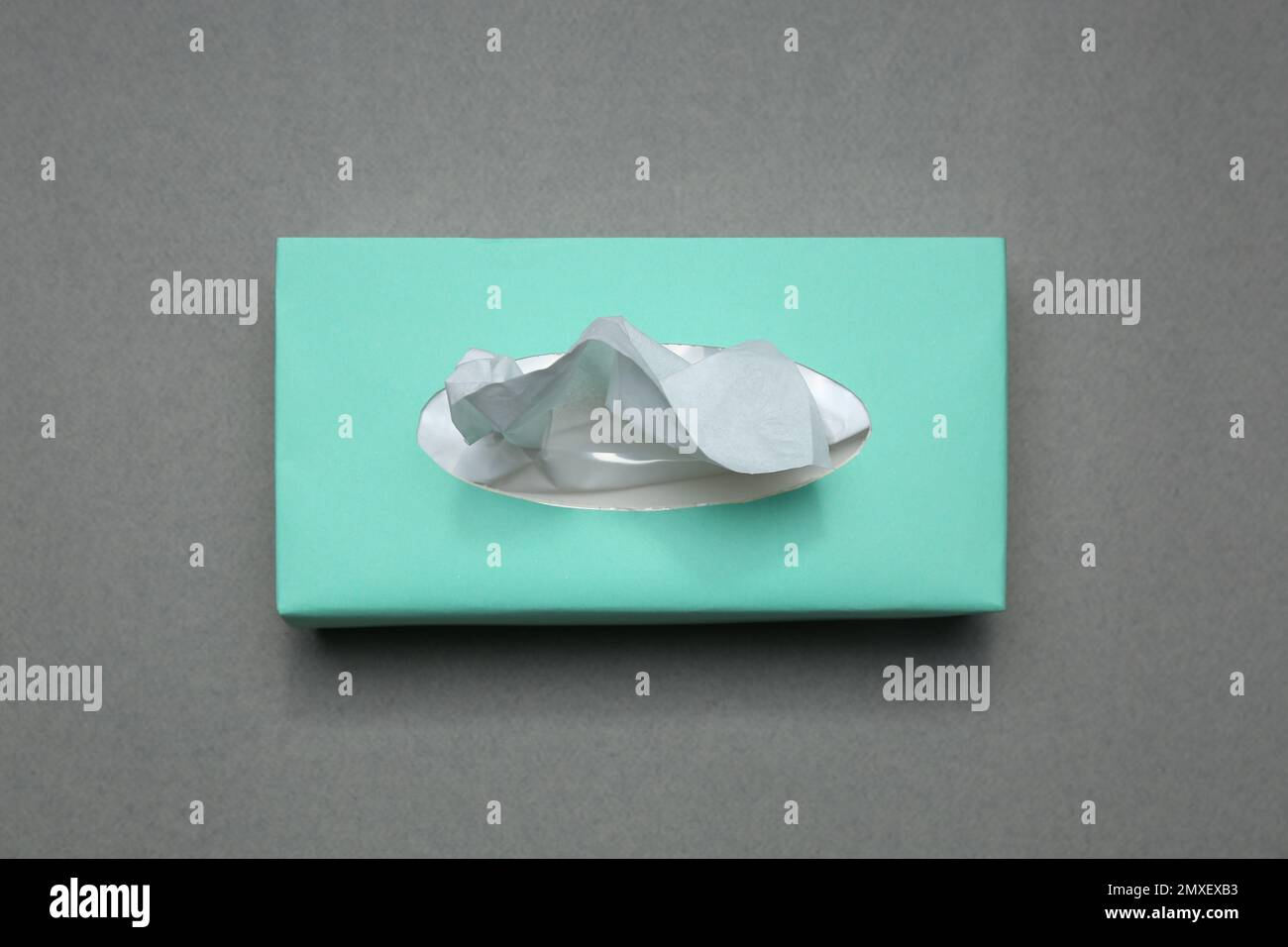 Confezione di fazzolettini di carta su sfondo grigio, vista dall'alto Foto Stock