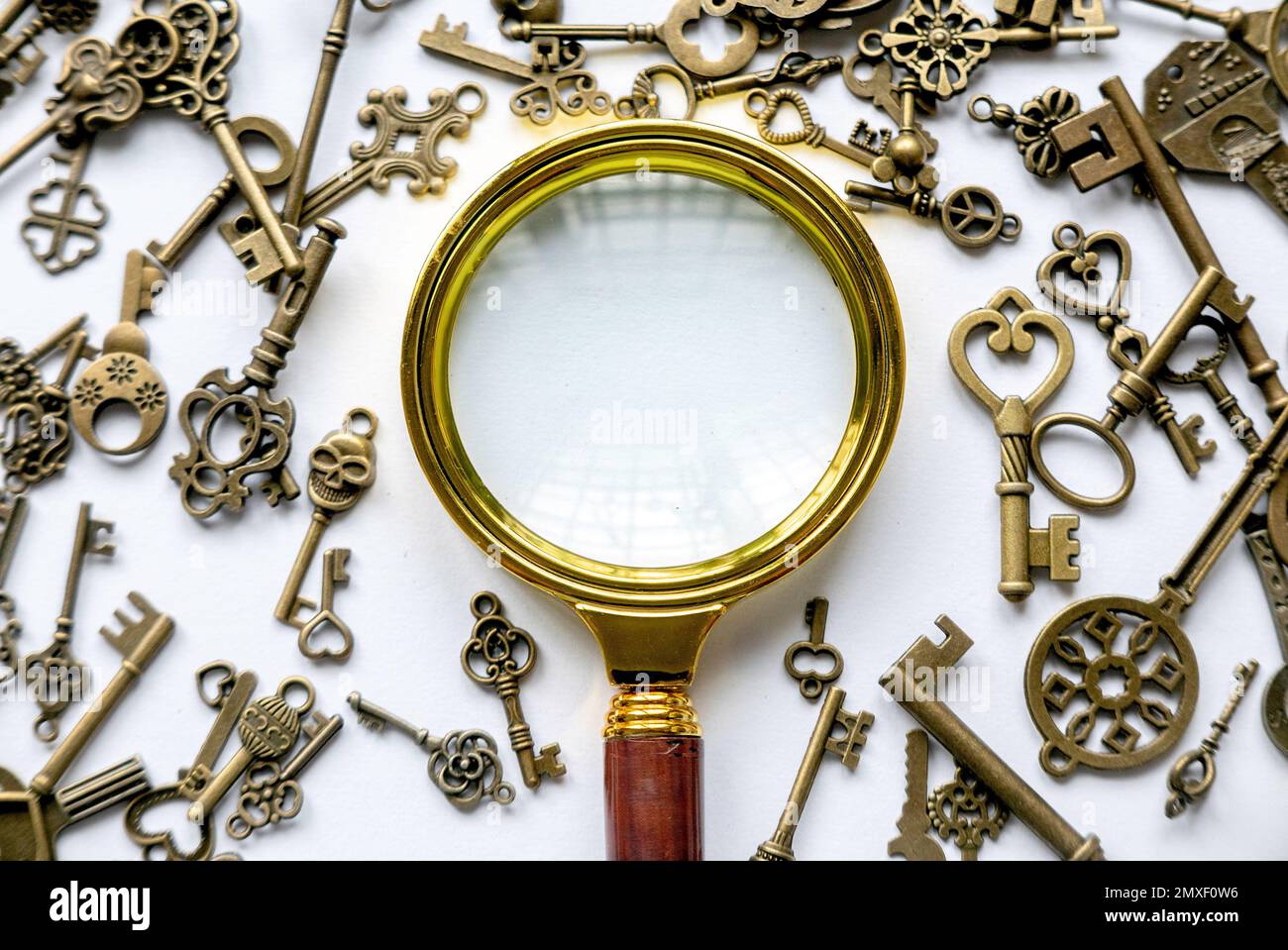 Lente d'ingrandimento e un gruppo di chiavi. Concetto di ricerca della soluzione. Foto Stock