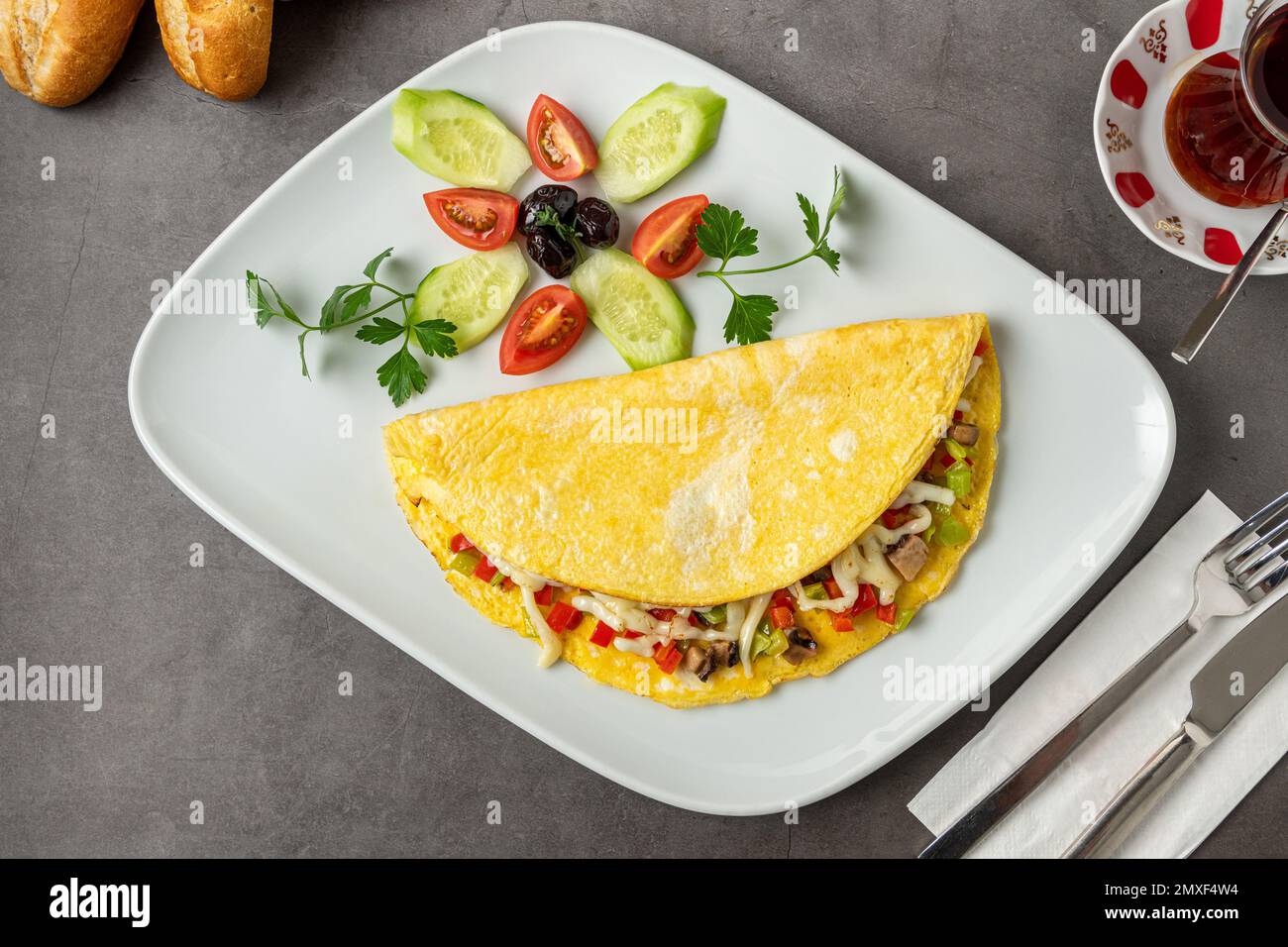Omelette con formaggio, funghi e verdure su un piatto di porcellana bianca Foto Stock
