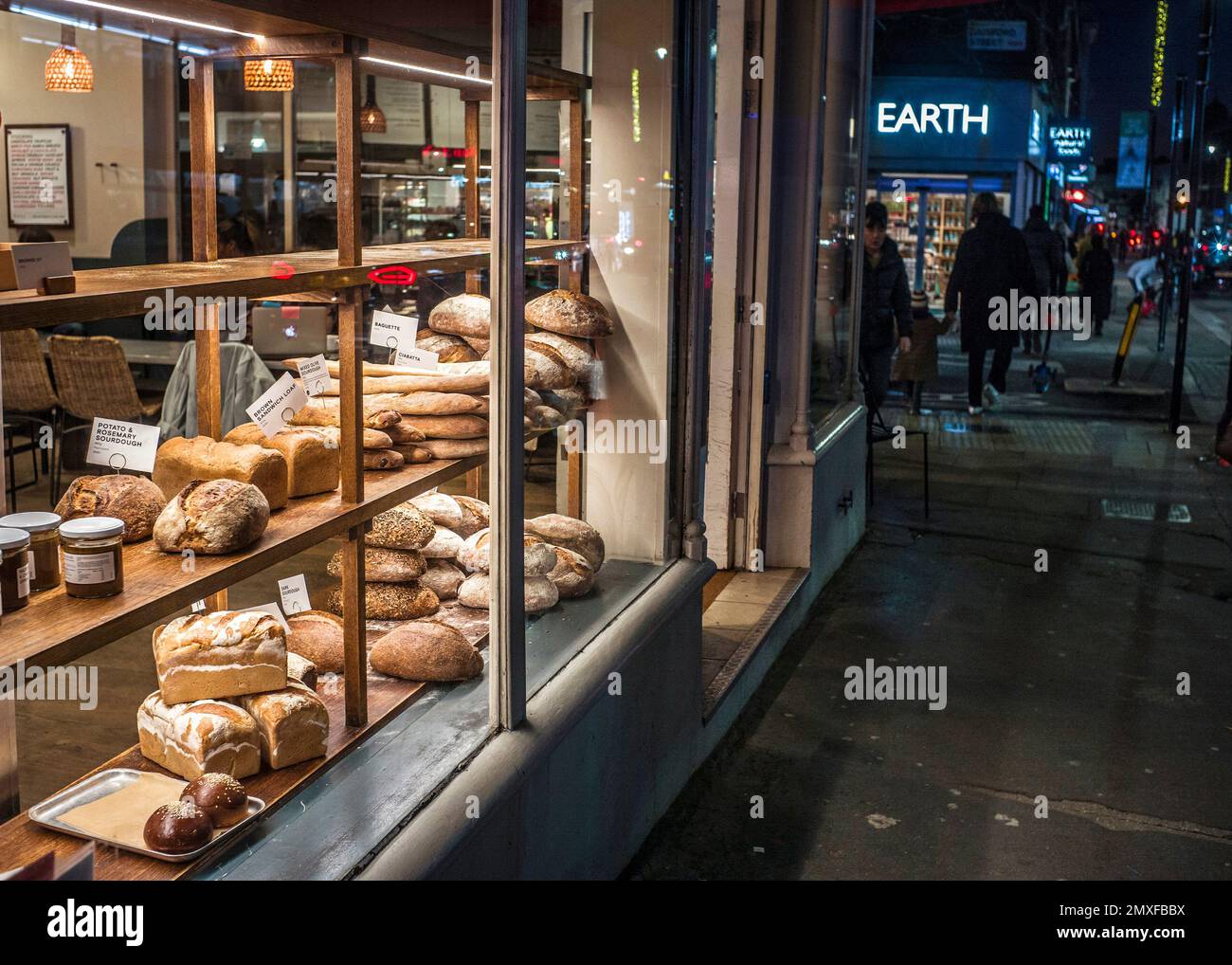 pane nella finestra del negozio scena notturna di strada Foto Stock