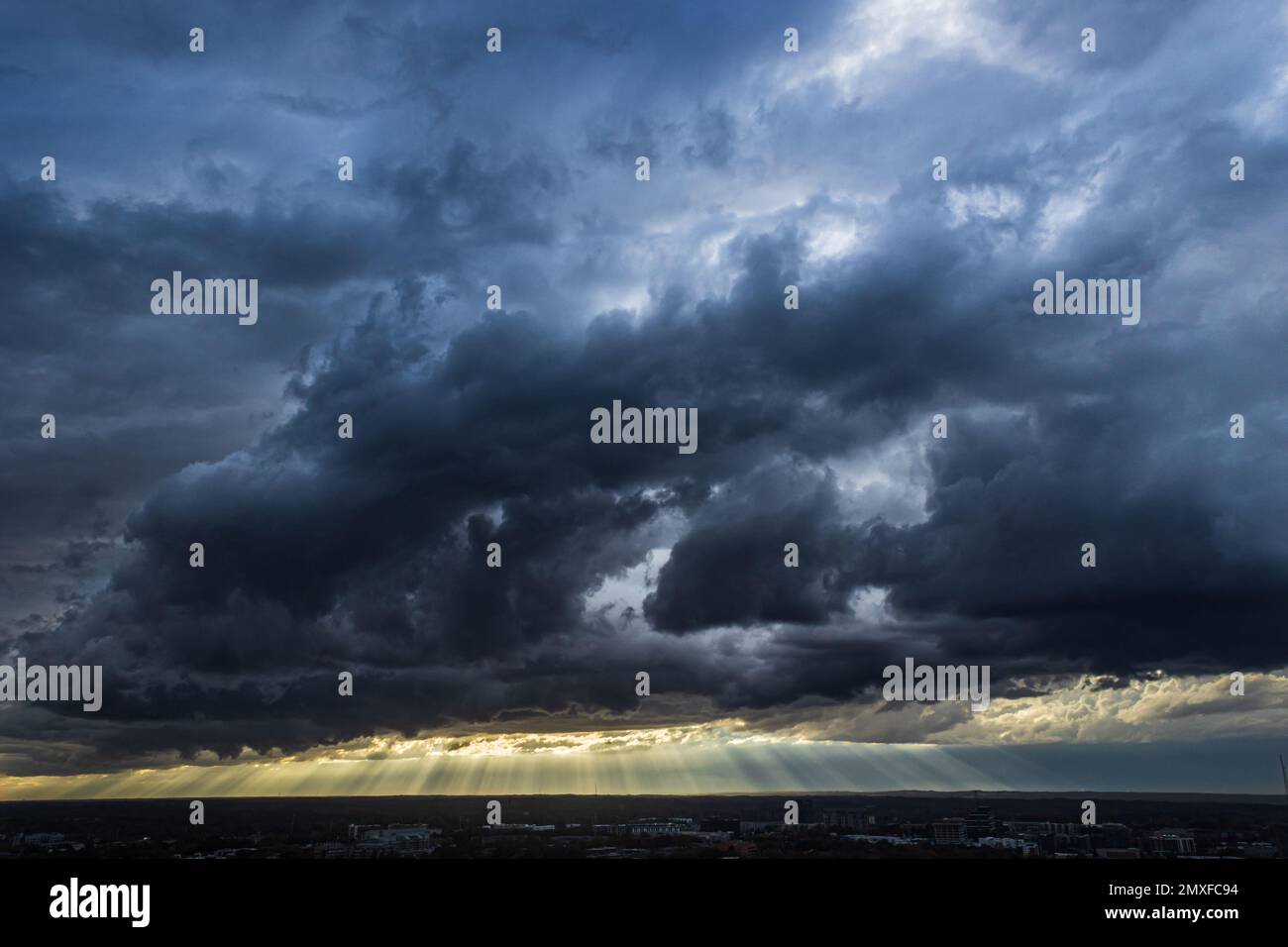 I raggi del sole tagliano le nuvole buie e minacciose della tempesta che si avvolgono nel centro di Atlanta. Foto Stock