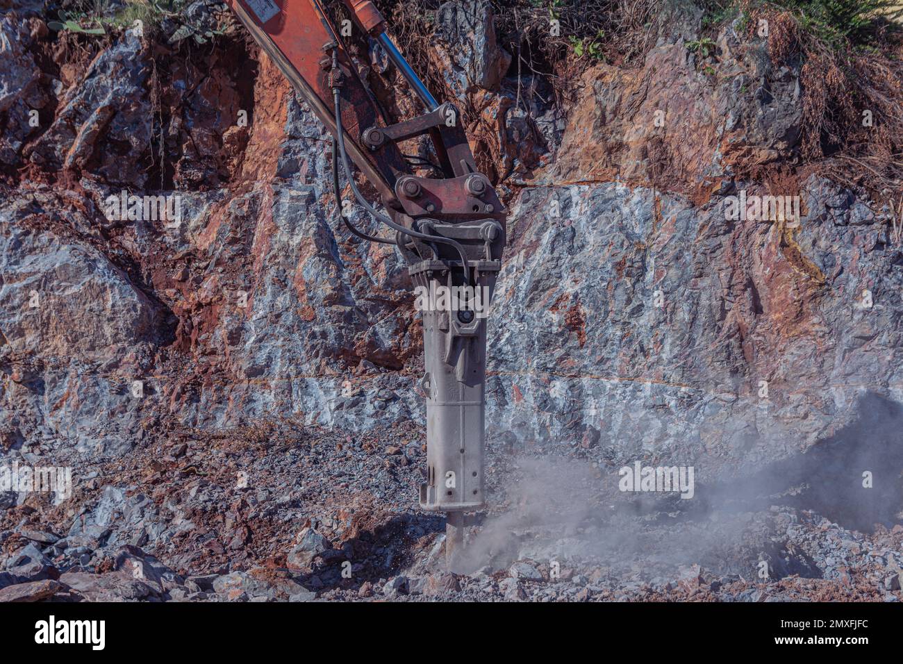 Macchine pesanti lavorano nel cantiere. Suolo roccioso di radura per costruzione in Turchia. L'escavatore schiaccia la roccia. Foto Stock