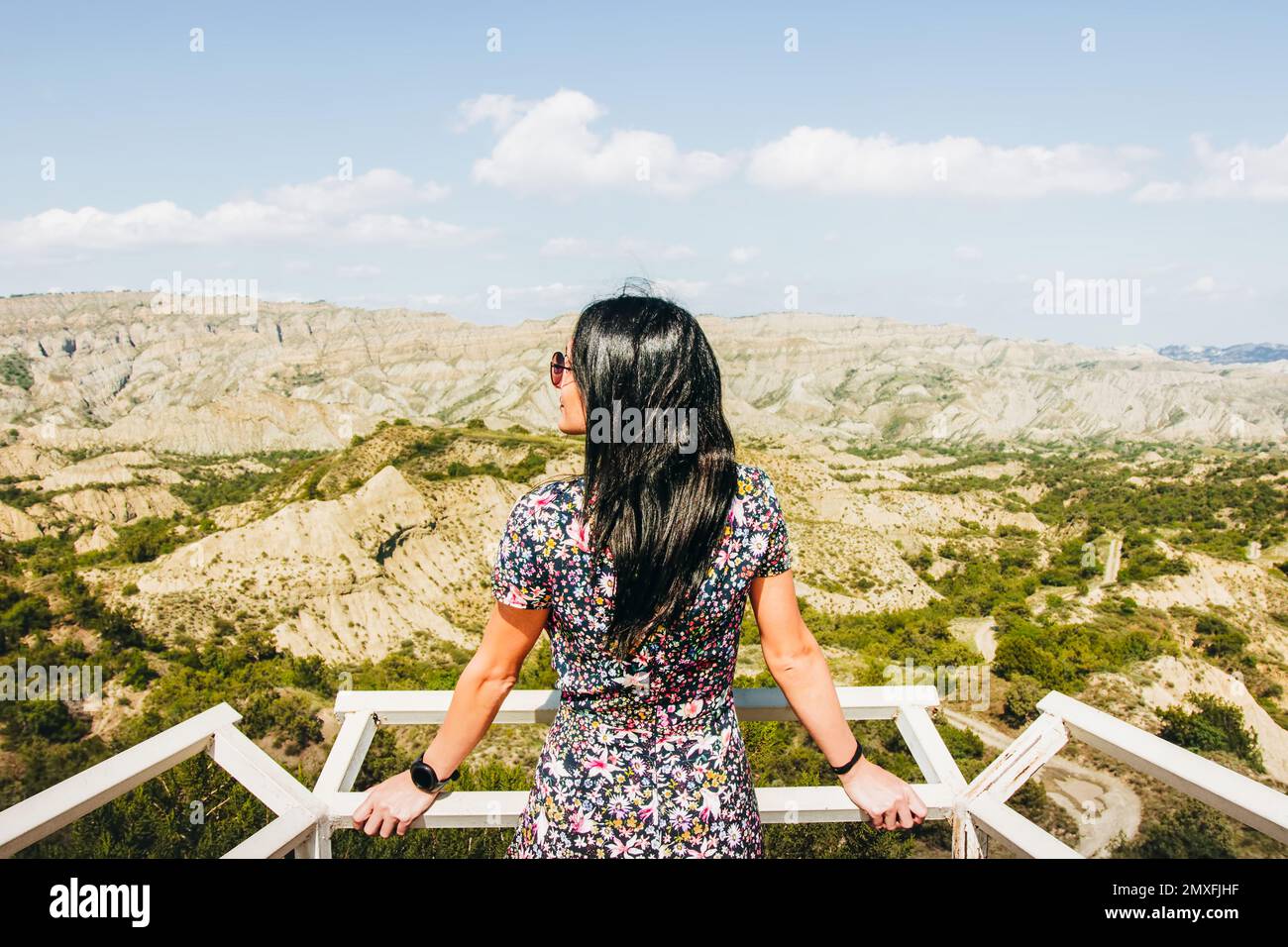 La donna brunette si erge sul punto di osservazione della piattaforma e guarda a sinistra sullo splendido paesaggio della riserva naturale di Vashlovani Foto Stock