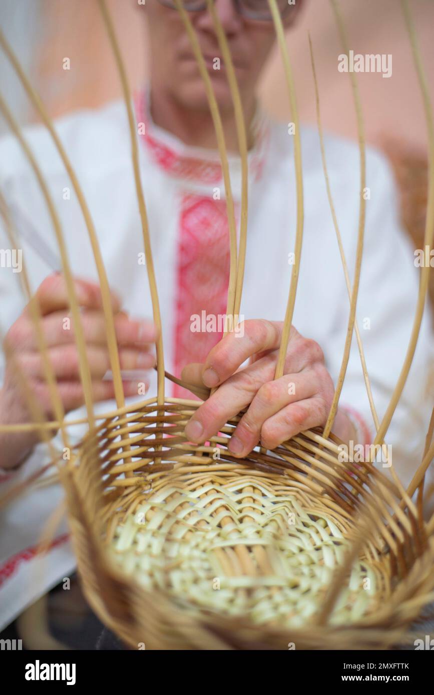l'uomo tesse i cestini dai rami del salice. artigianato popolare Foto Stock