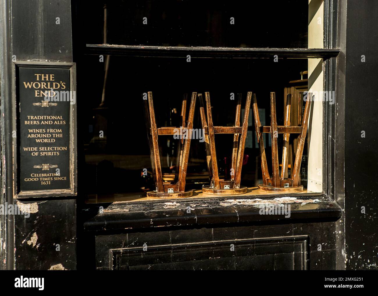 Sgabelli impilati capovolti all'interno della casa pubblica dei Mondi End Camden Foto Stock