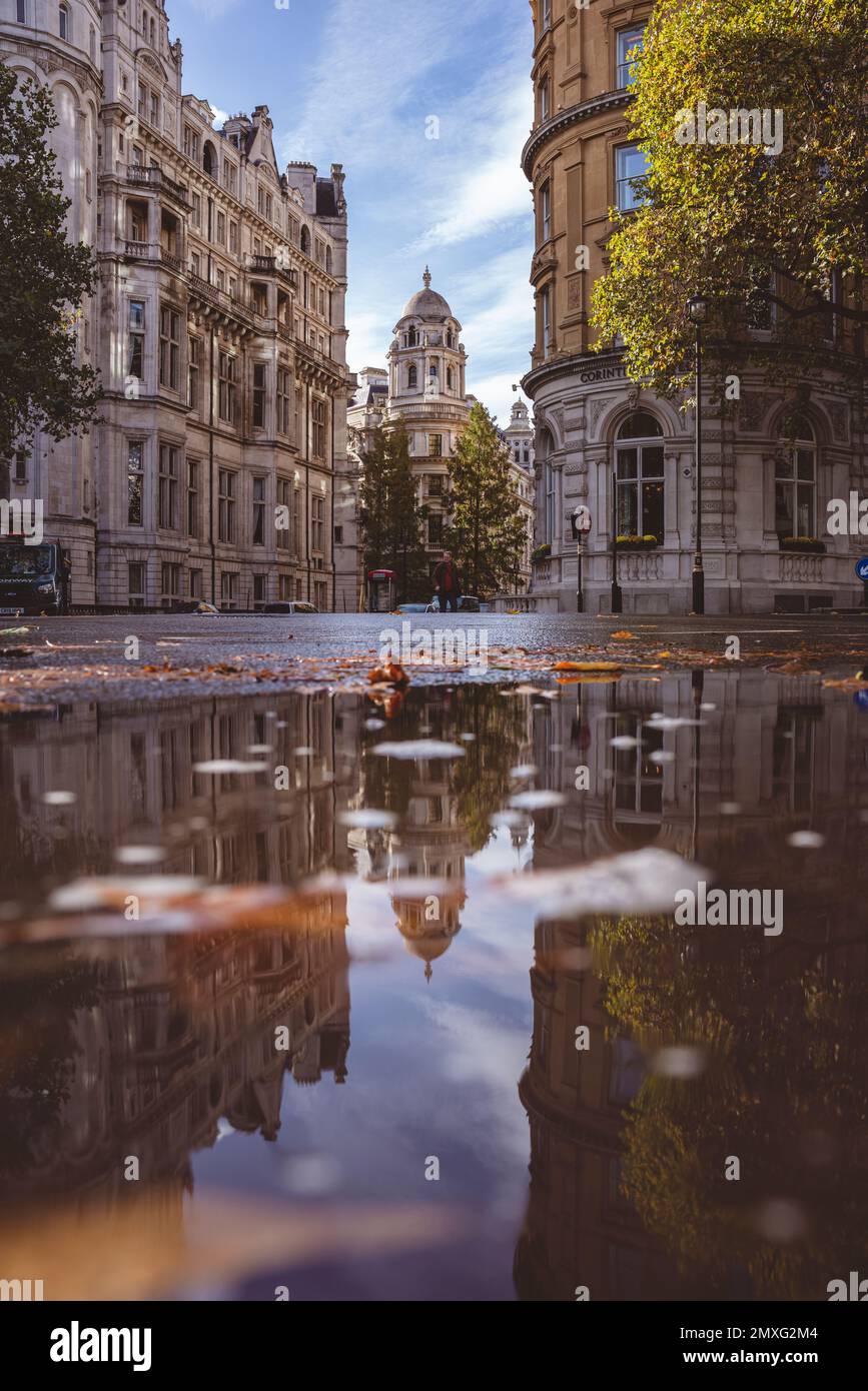 Un'immagine verticale dell'Old War Office Building circondato da edifici che si riflettono nell'acqua di Londra, Regno Unito Foto Stock