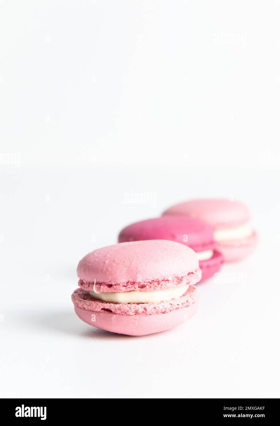 Pila di macaron rosa su sfondo bianco Foto Stock