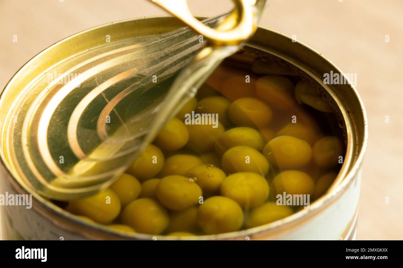 lattina con piselli verdi su uno sfondo isolato primo piano Foto Stock