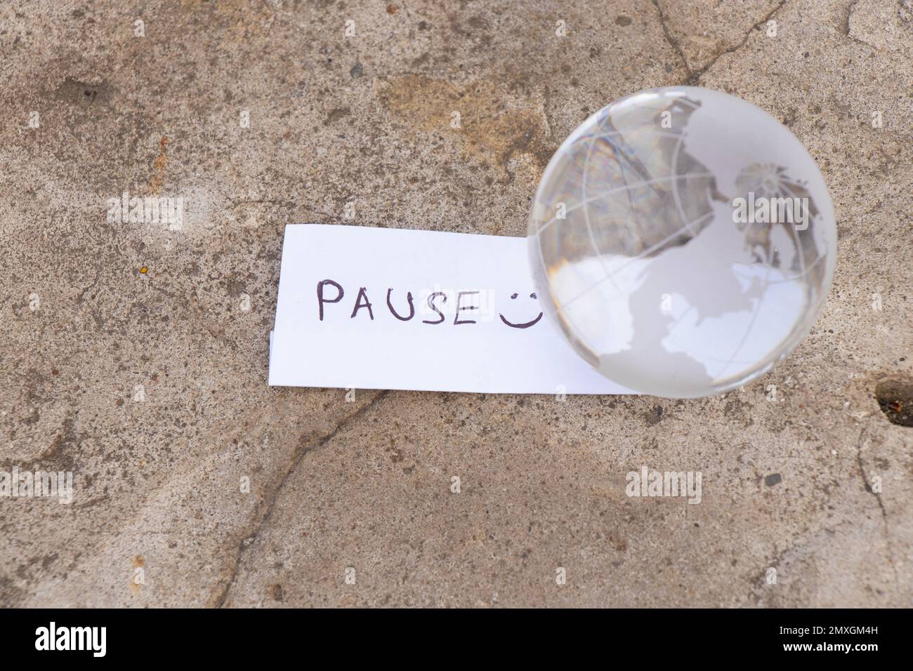 La parola pausa in inglese e un globo di vetro Foto Stock