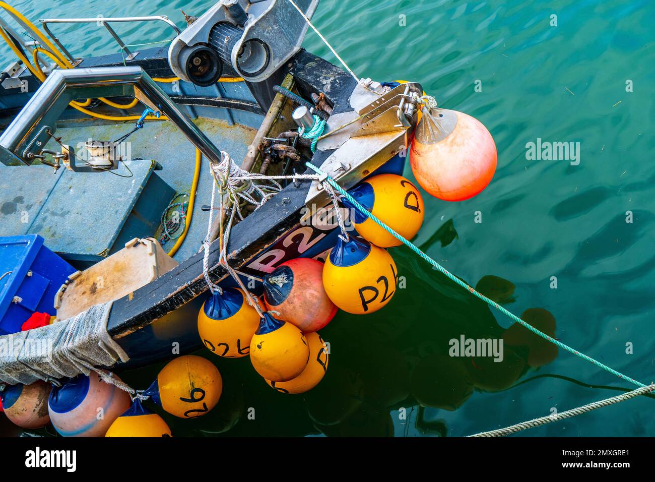 Parafanghi colorati su un peschereccio ancorato nel porto di West Bay - industria della pesca del Regno Unito. Foto Stock