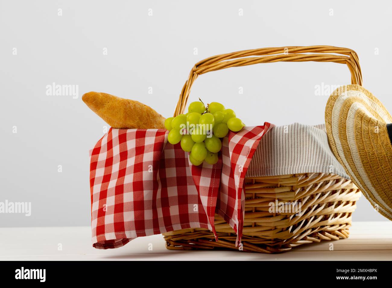 Cestino da picnic con tessuto vichy rosso e bianco e cibo su sfondi bianchi Foto Stock