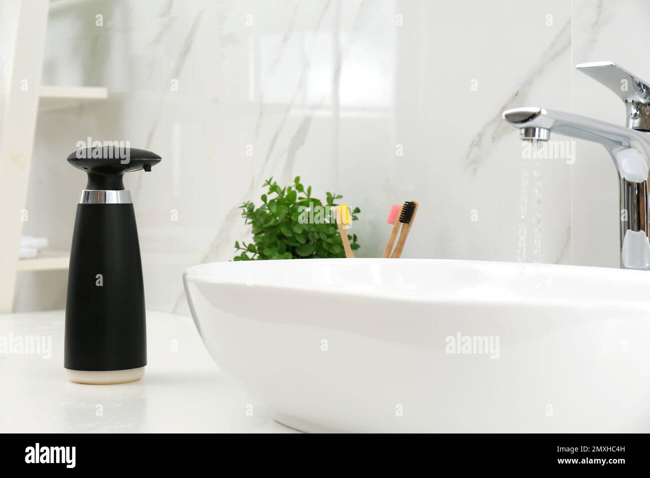 Dispenser di sapone automatico moderno vicino al lavandino in bagno,  guardaroba Foto stock - Alamy