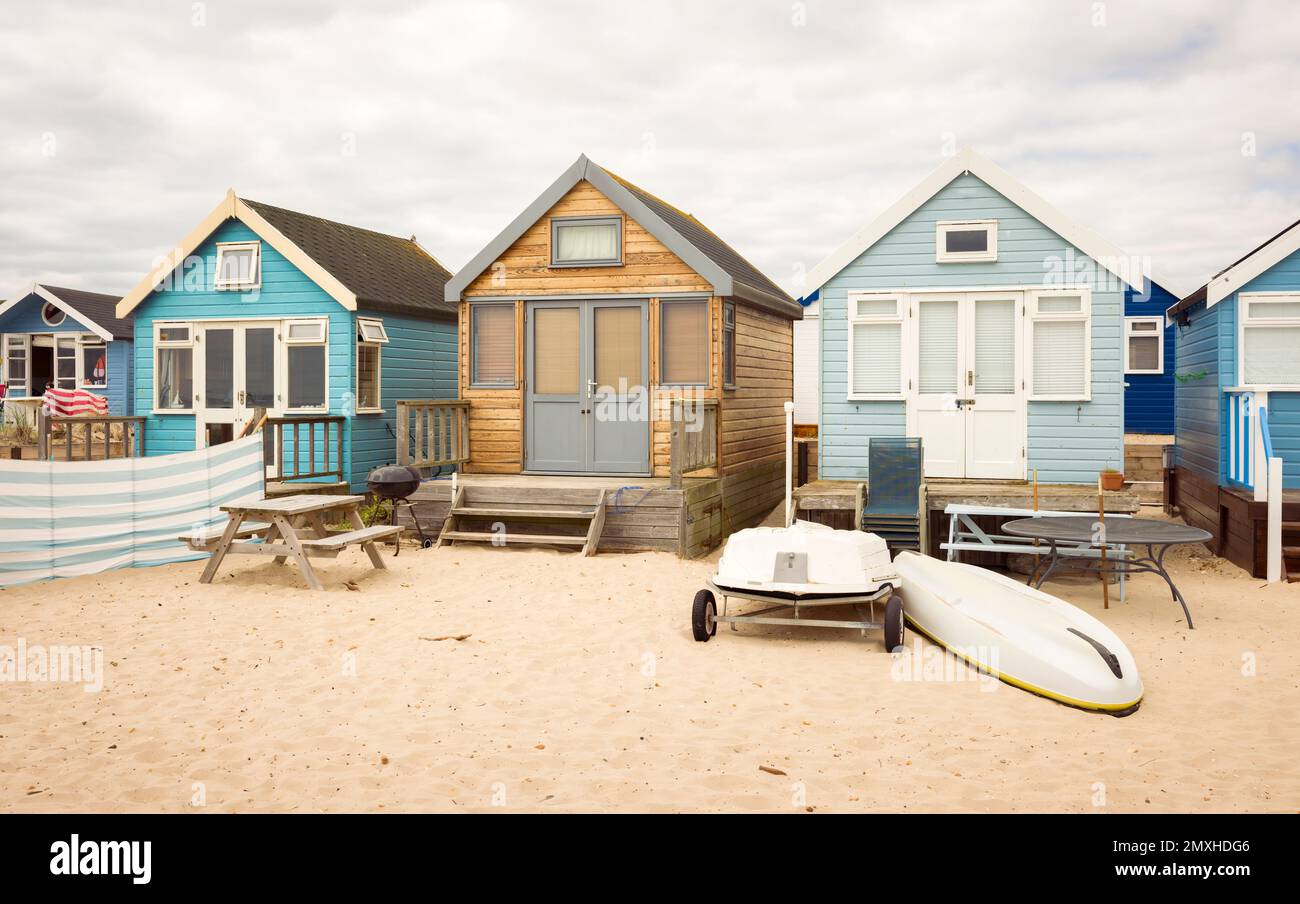 Fila di case in legno sulla spiaggia di sabbia. Hengistbury Head, Dorset, Regno Unito Foto Stock