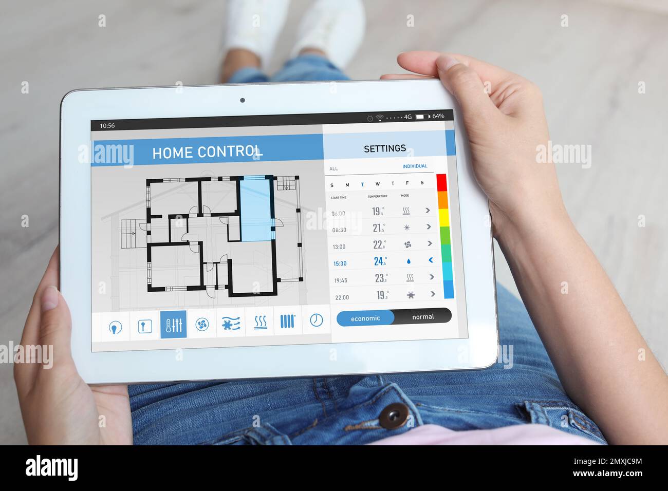 Donna che utilizza il sistema di controllo domestico a risparmio energetico su tablet, primo piano Foto Stock