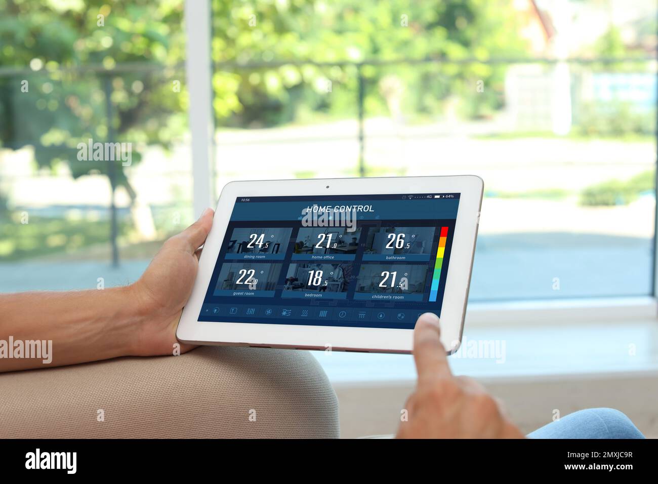 Sistema di controllo domestico ad efficienza energetica. Uomo che usa il tablet per impostare la temperatura in stanze diverse, primo piano Foto Stock